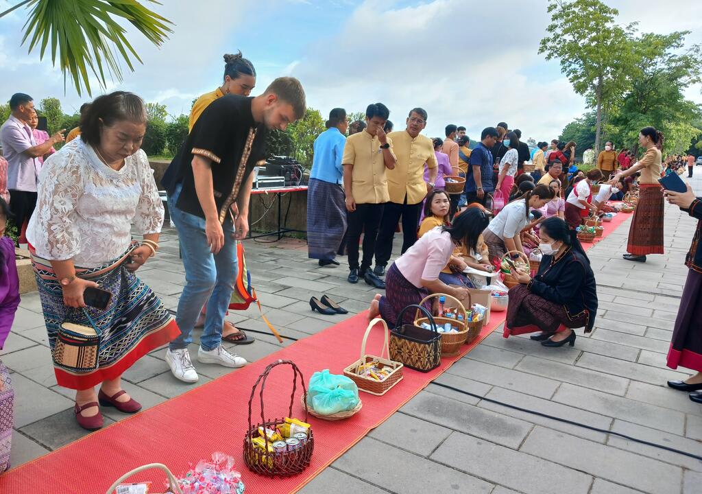 Western guy in a "alms giving" buddhist ceremony in Thailand