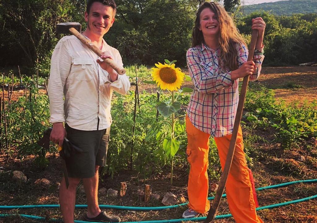 Chico y chica trabajando la tierra en un jardín amplio