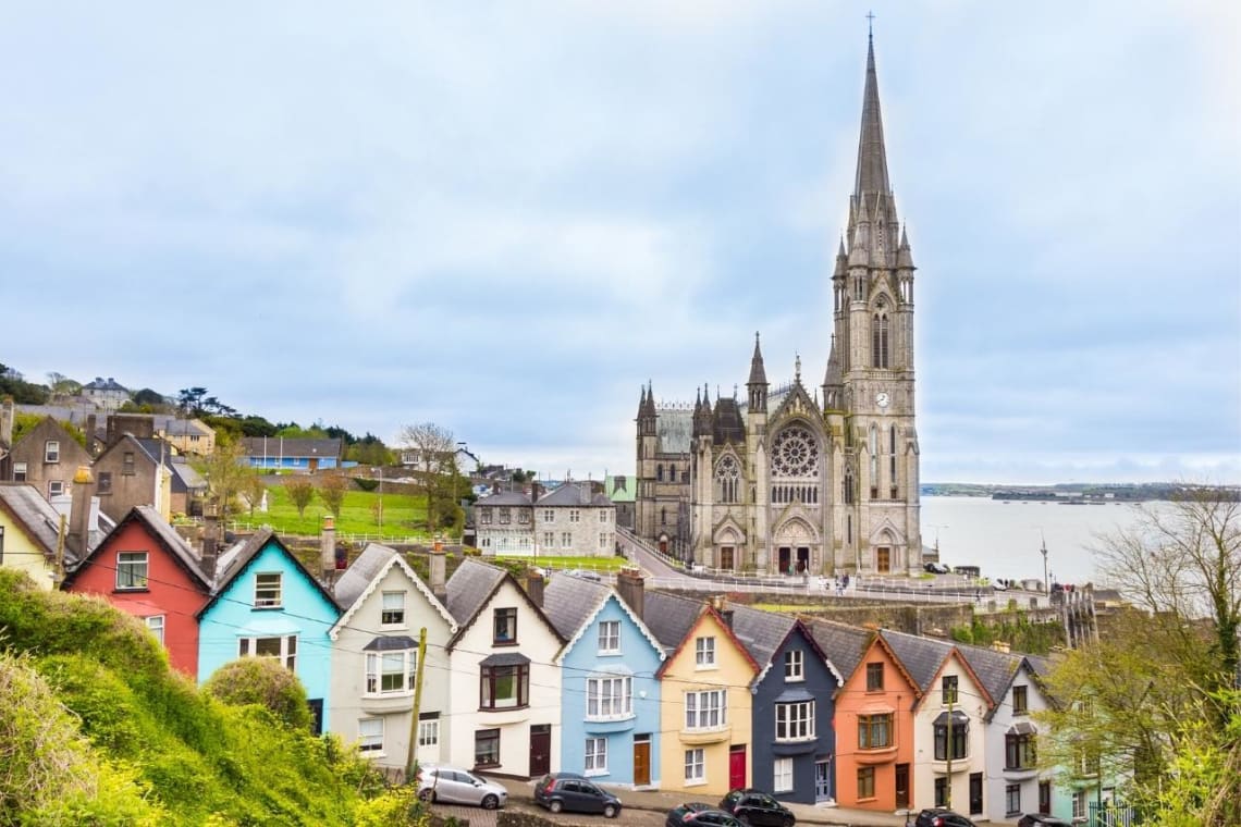 Casas coloridas e Iglesia de Santa Ana detrás en Cork, Irlanda