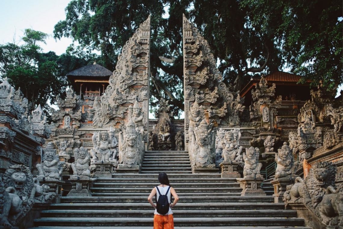 Girl admiring an intricately decorated temple entrance in Bali