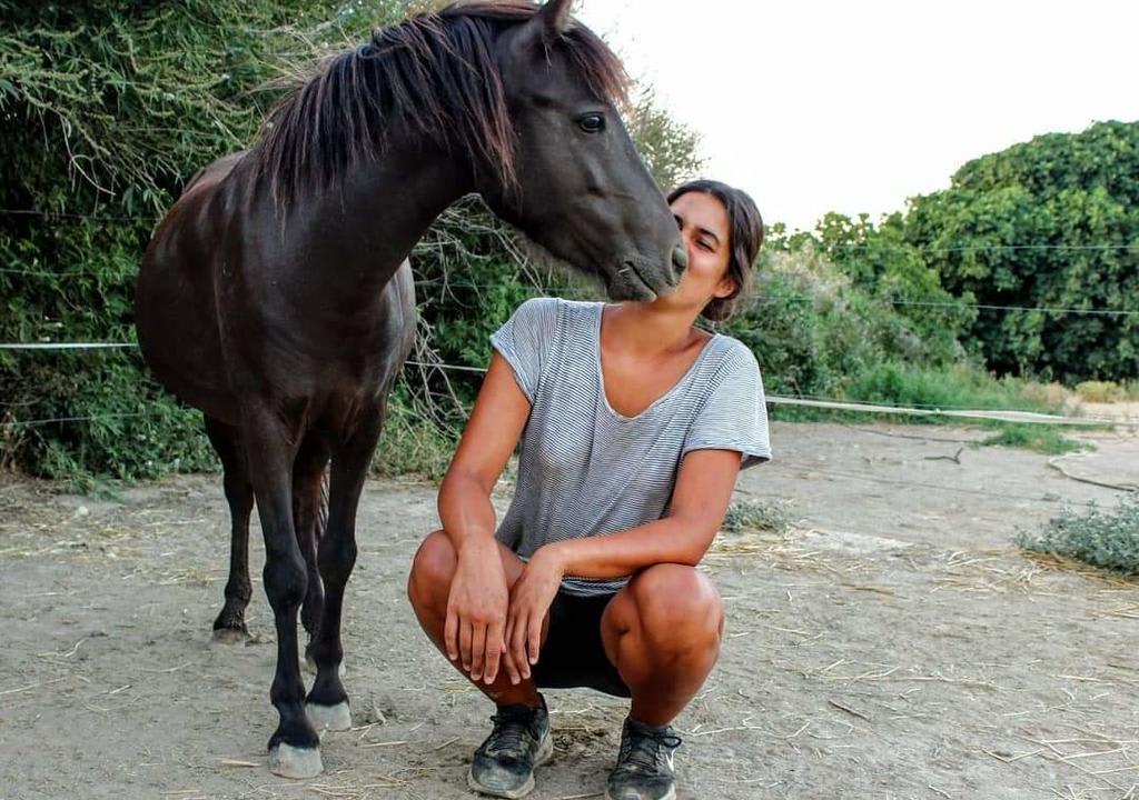 Chica besando a un caballo en zona rural