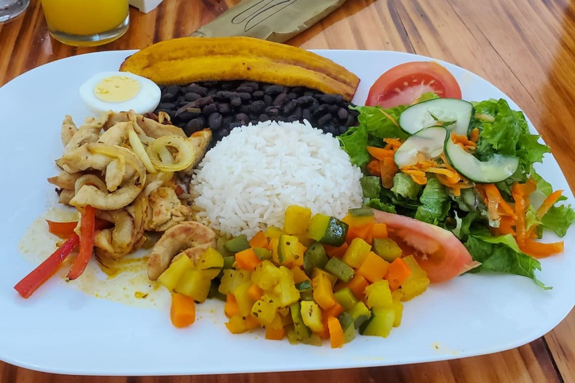 Dish with rice, black beans, vegetables, chicken and fried plantain, traditional food of Puerto Rico