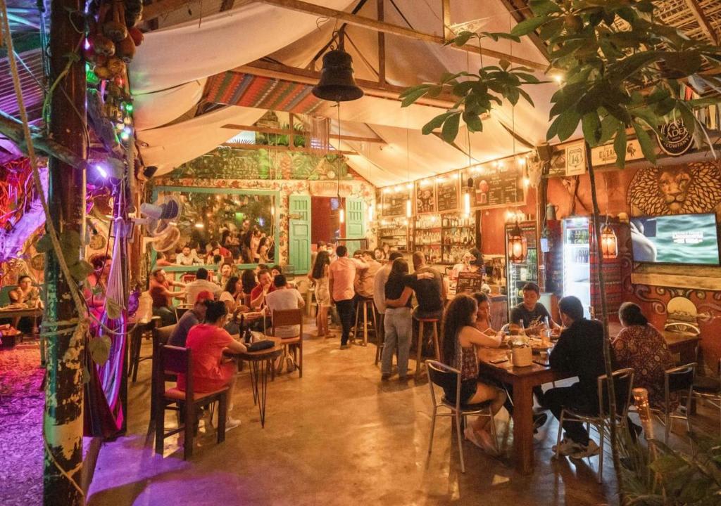 Bar del Hostel Los Amigos por la noche lleno de gente