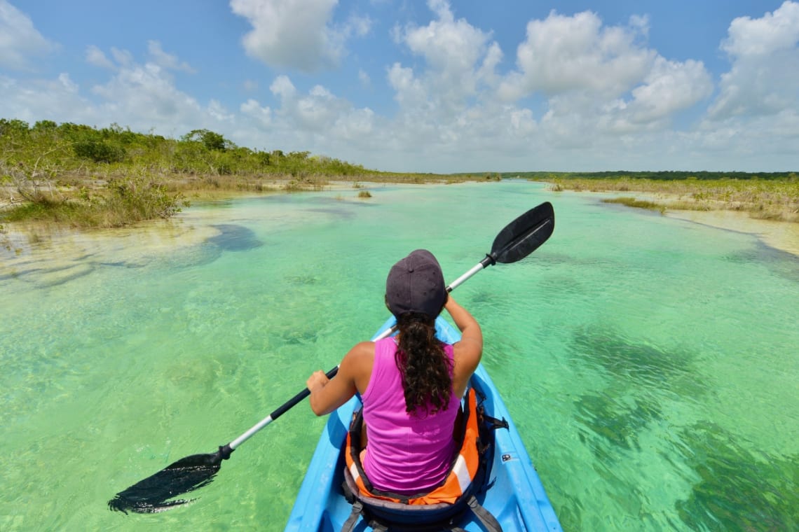 Chica en kayak remando por la laguna de Bacalar