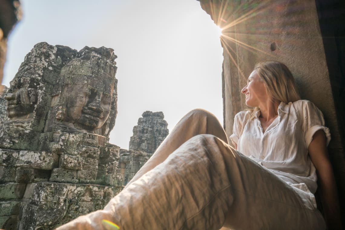 Is Cambodia safe? Tourist admiring the carvings of a temple in Angkor