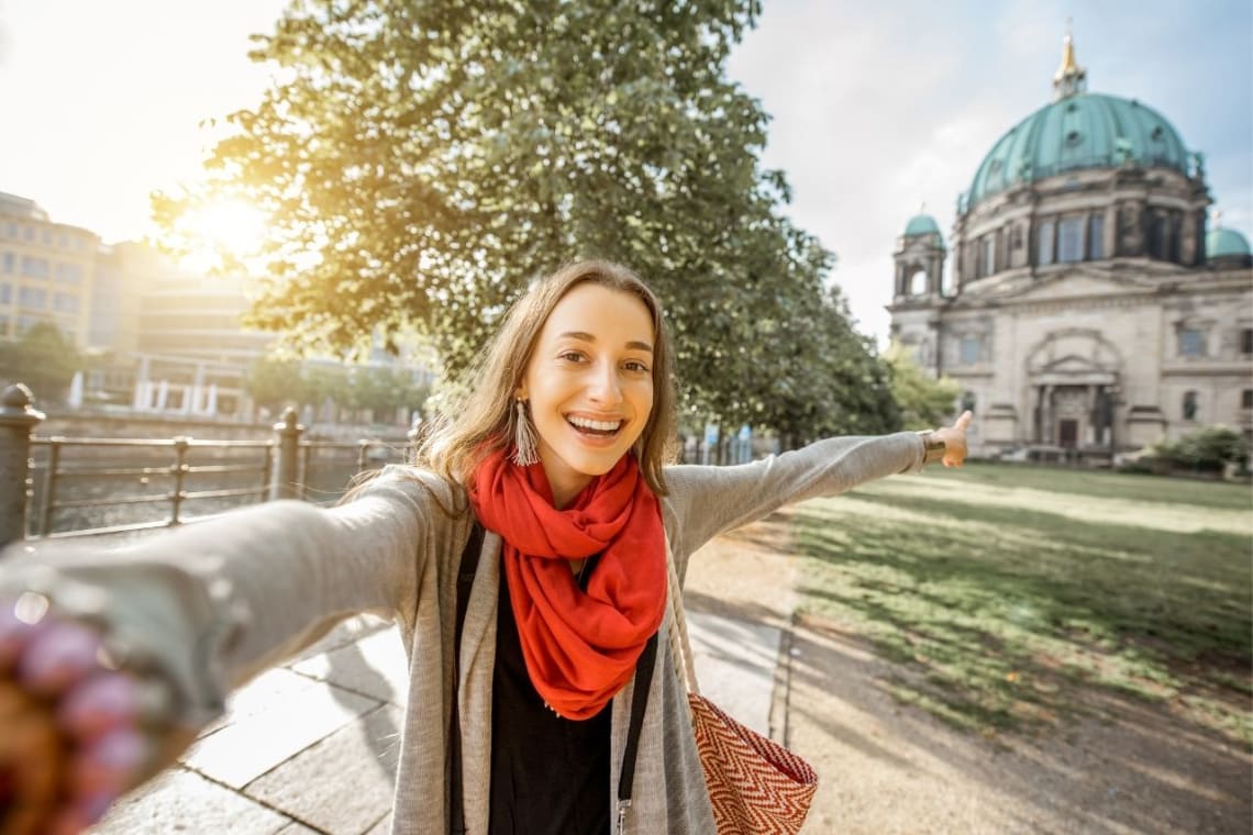 Travel influencer taking a selfie in front of a landmark building