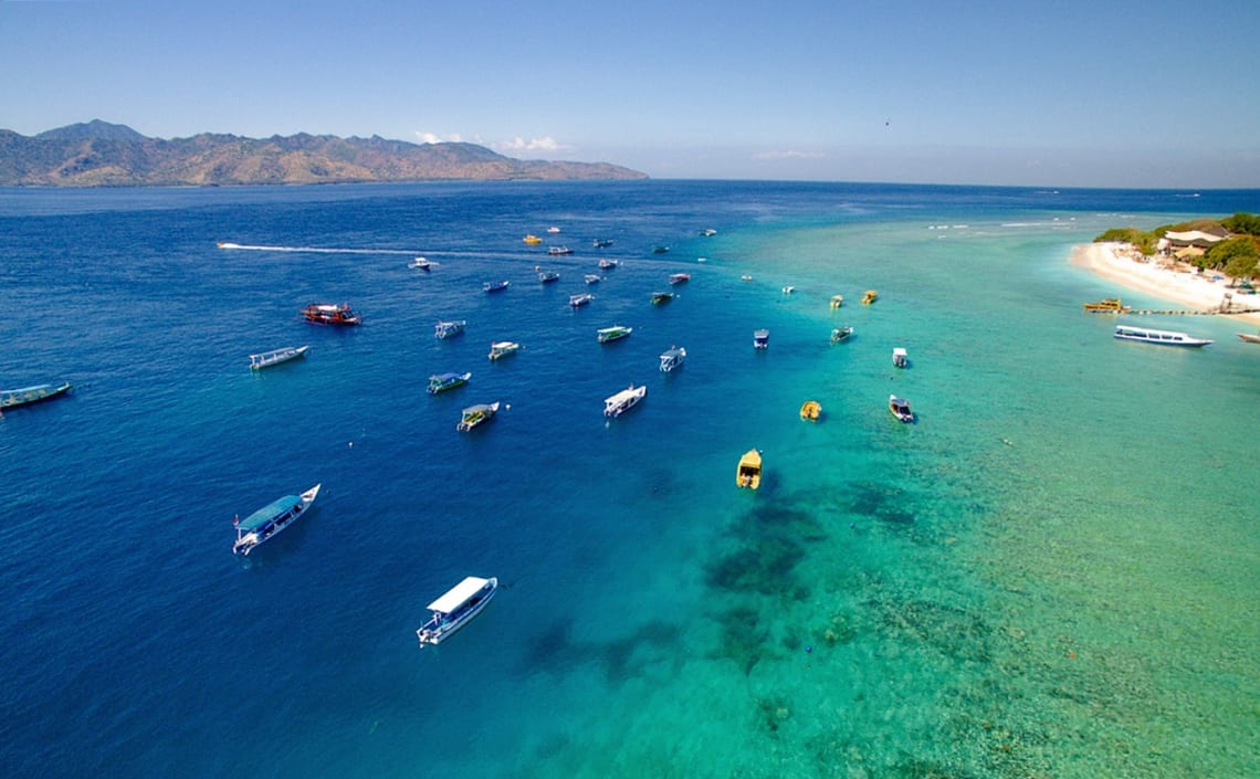 Costa de una de las islas Gili con muchos barcos