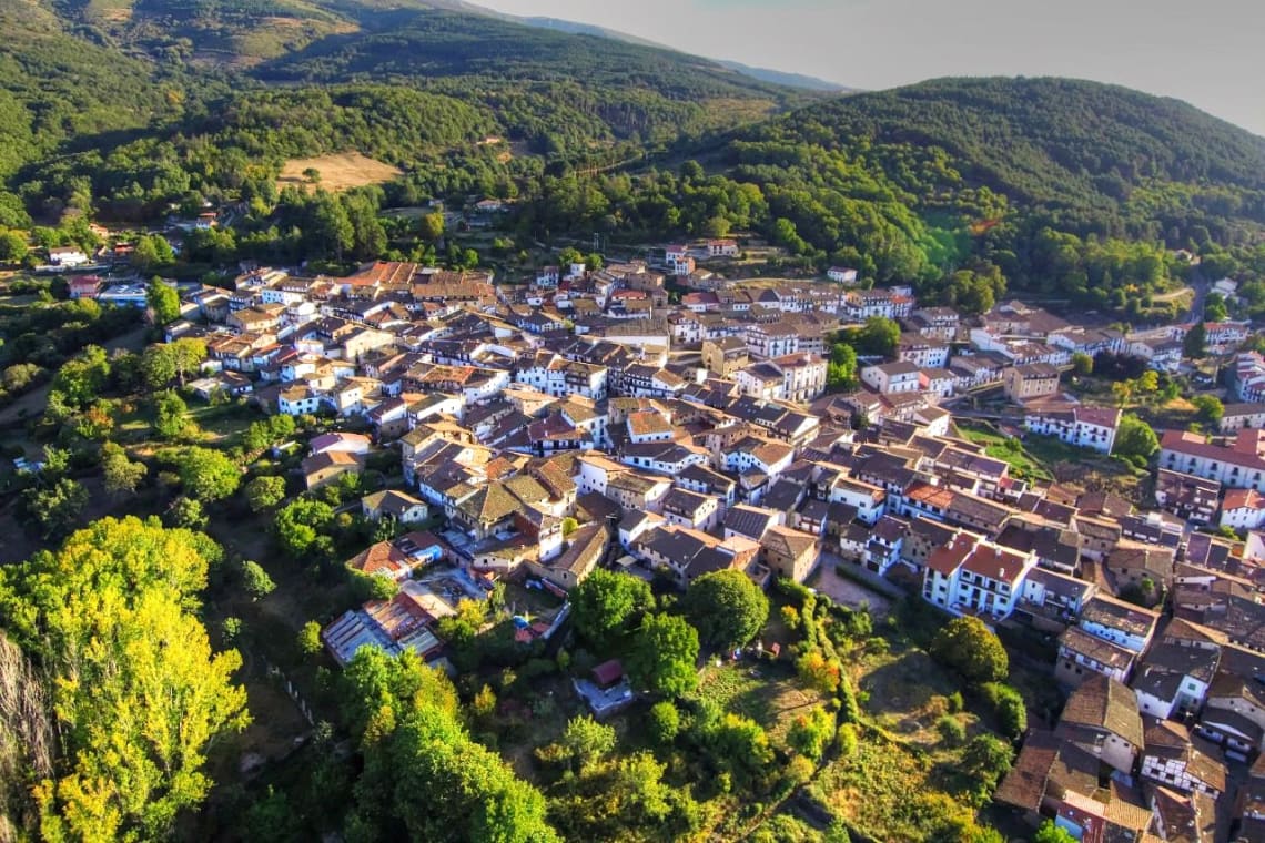 Vista aérea de pueblo en zona de montaña rodeada de bosque