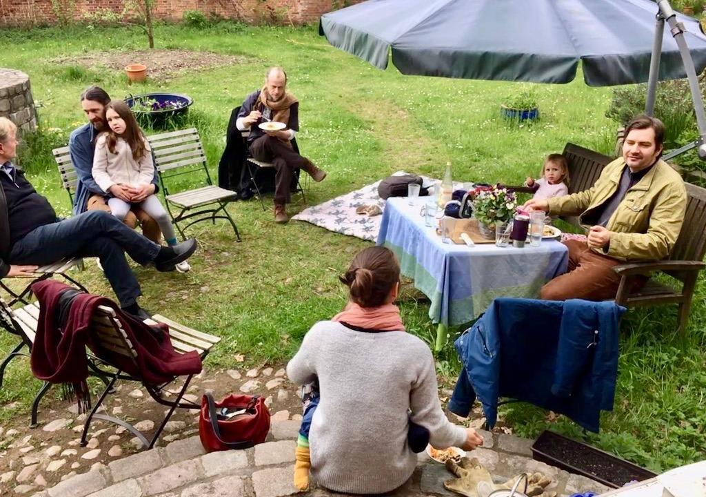 Gruop of volunteers having a vegan lunch in a garden