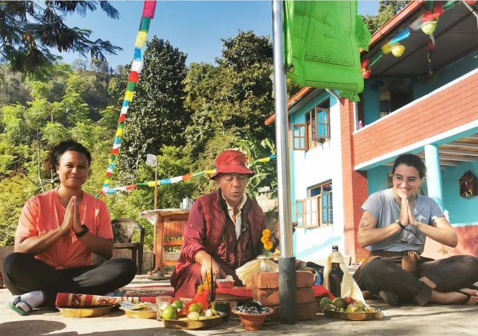 Two girls sharing a religious ritual with a buddhist monk