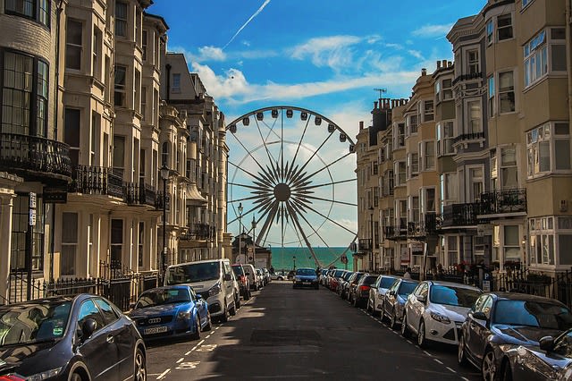 Foto de rua em Brighton e ao fundo o mar e uma roda gigante, ótimo destino para uma viagem lgbt