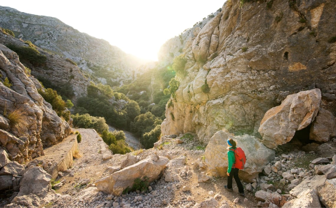 Chica haciendo senderismo en zona de montaña de España