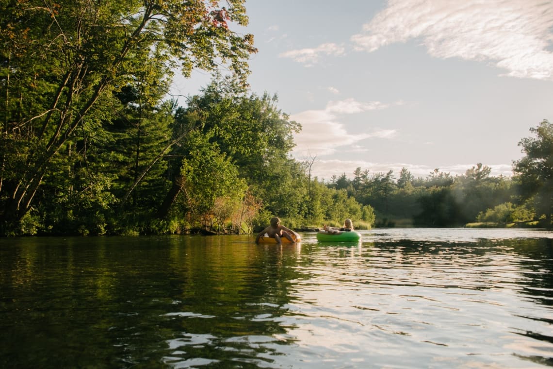 Dos personas haciendo tubing en el río