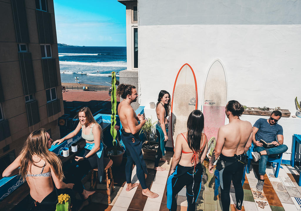 Jóvenes en la terraza de un surf hostel, una de las oportunidades de trabajo en Canarias con alojamiento