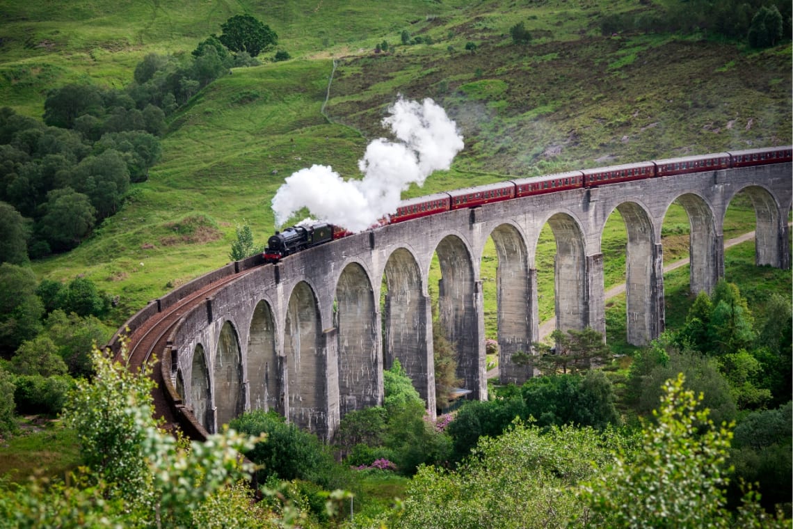 Tren a vapor pasando por un viaducto