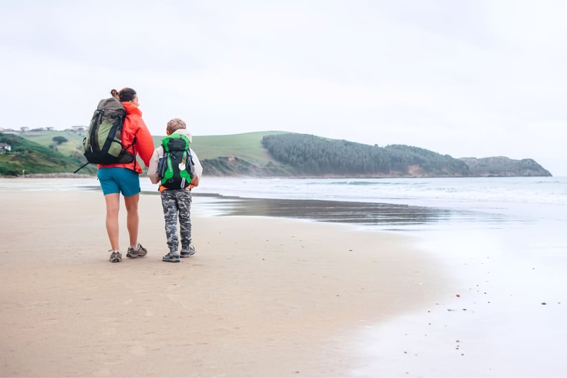 Madre con hijo en la playa haciendo el Camino del norte