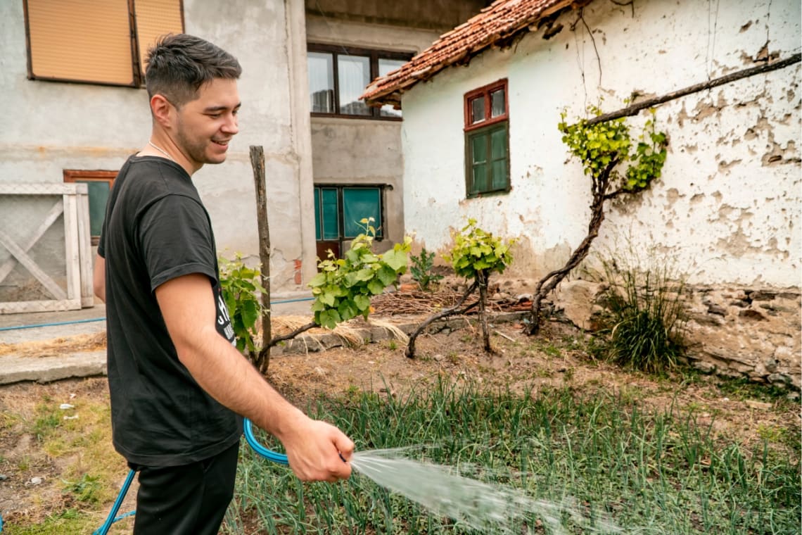 Cuidador de casas regando un jardín