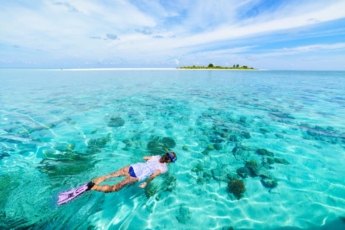 Chica haciendo snorkel en mar cristalino de las islas Wakatobi