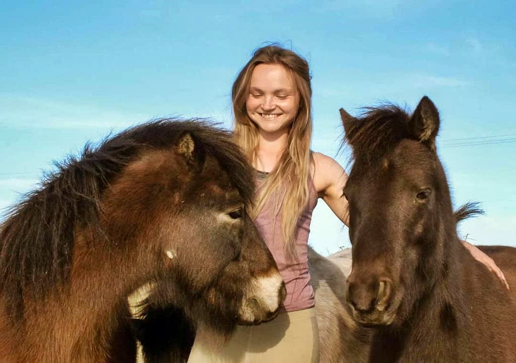 Girl petting two ponys