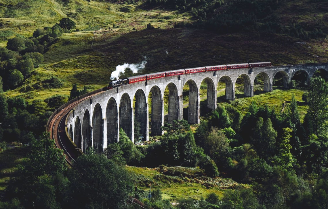 Train passing through a vast green landscape, UK