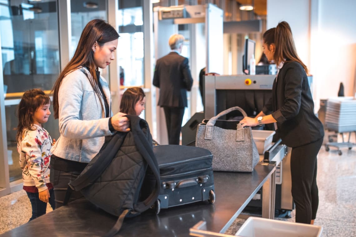 Turista de niña en el aeropuerto lleva una maleta con ruedas con una bolsa.  concepto sobre el tema del turismo.