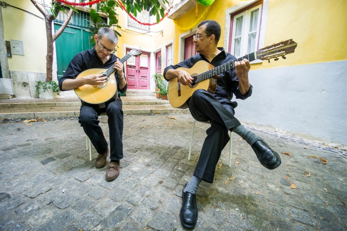 Dos hombres tocando la guitarra en una tranquila calle de Portugal