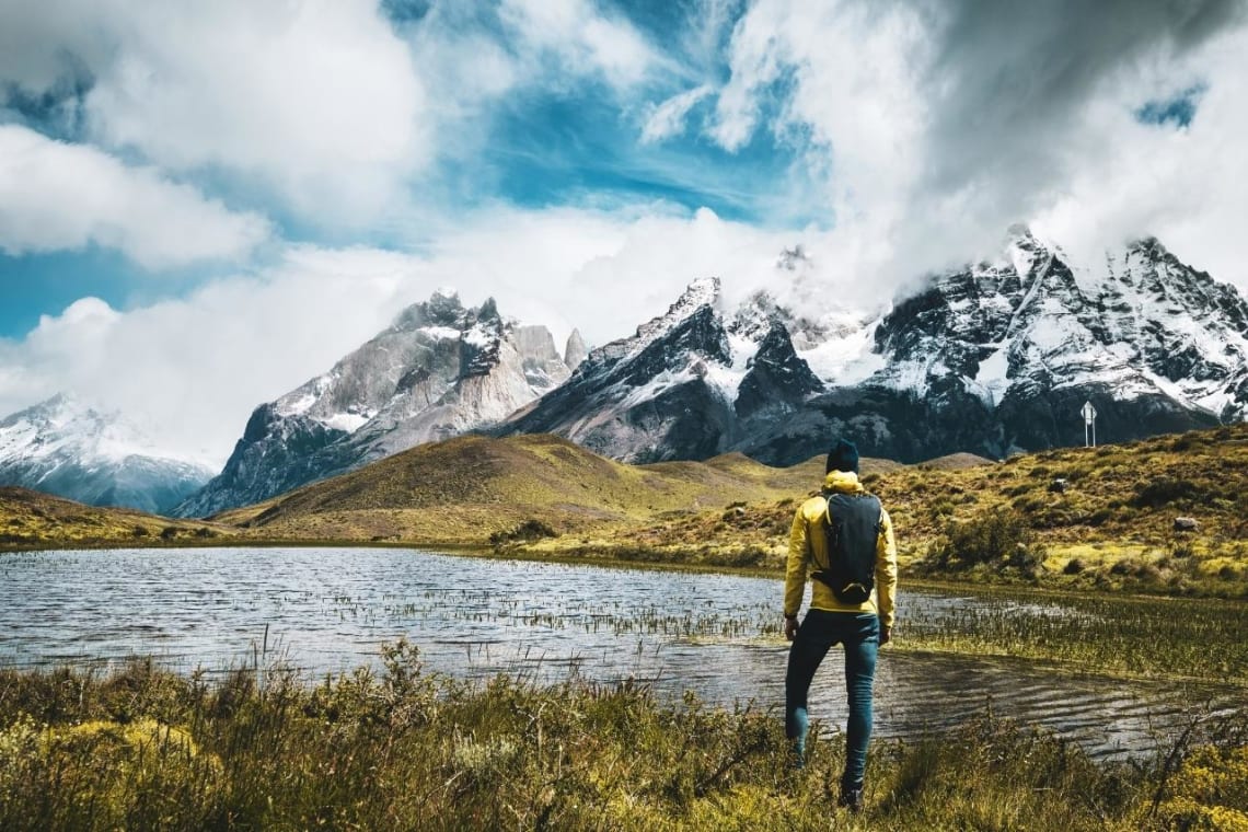 Joven mirando a montañas nevadas del Parque Nacional Torres del Paine
