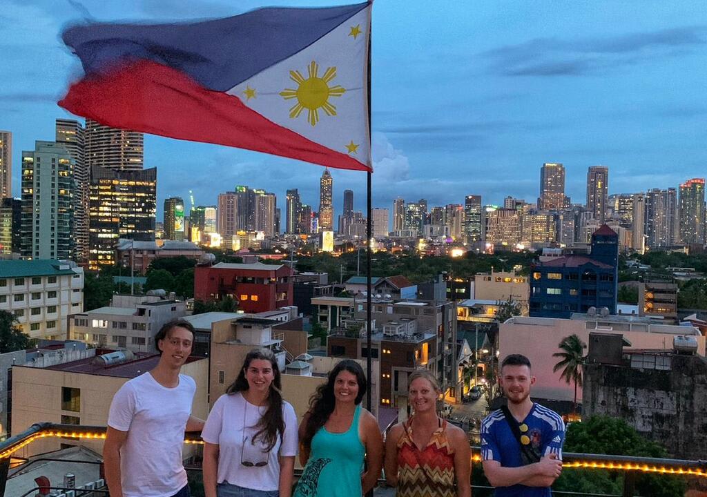 Group of volunteers at the rooftop of a hostel in Manila with the Filipino flag