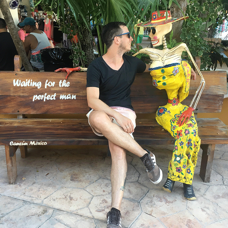 Todo lo que debes saber antes de viajar a Cancún: guía completa - Worldpackers - viajero en cancún con muñeco de la muerte 