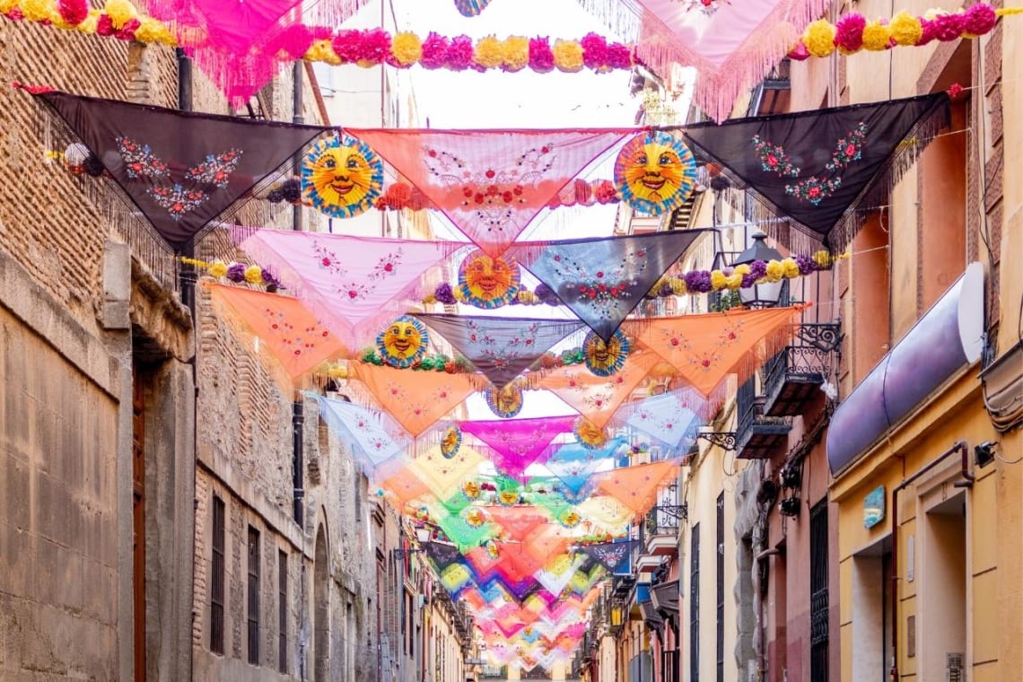 Colorida calle de Lavapiés con pañuelos atados de una lado al otro de la calle