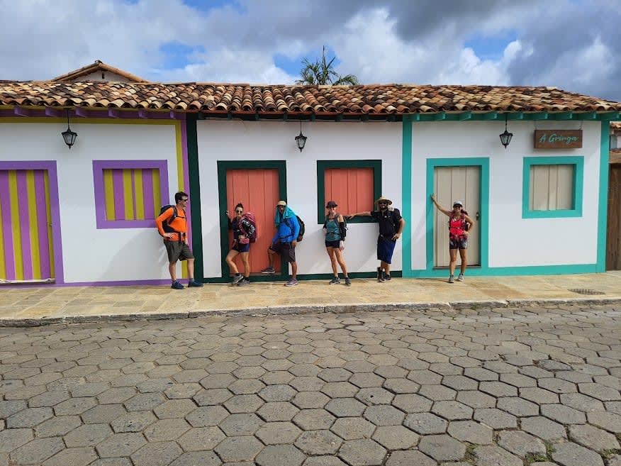 Viajantes posam em frente a casas coloridas em Pirenópolis