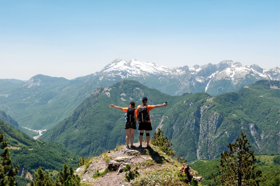 Couple reached a lookout point after a hike in the Albanian Alps