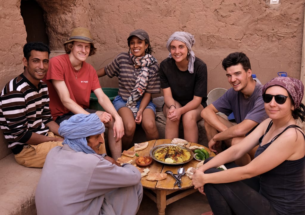Voluntarios compartiendo una comida tradicional con anfitriones marroquíes