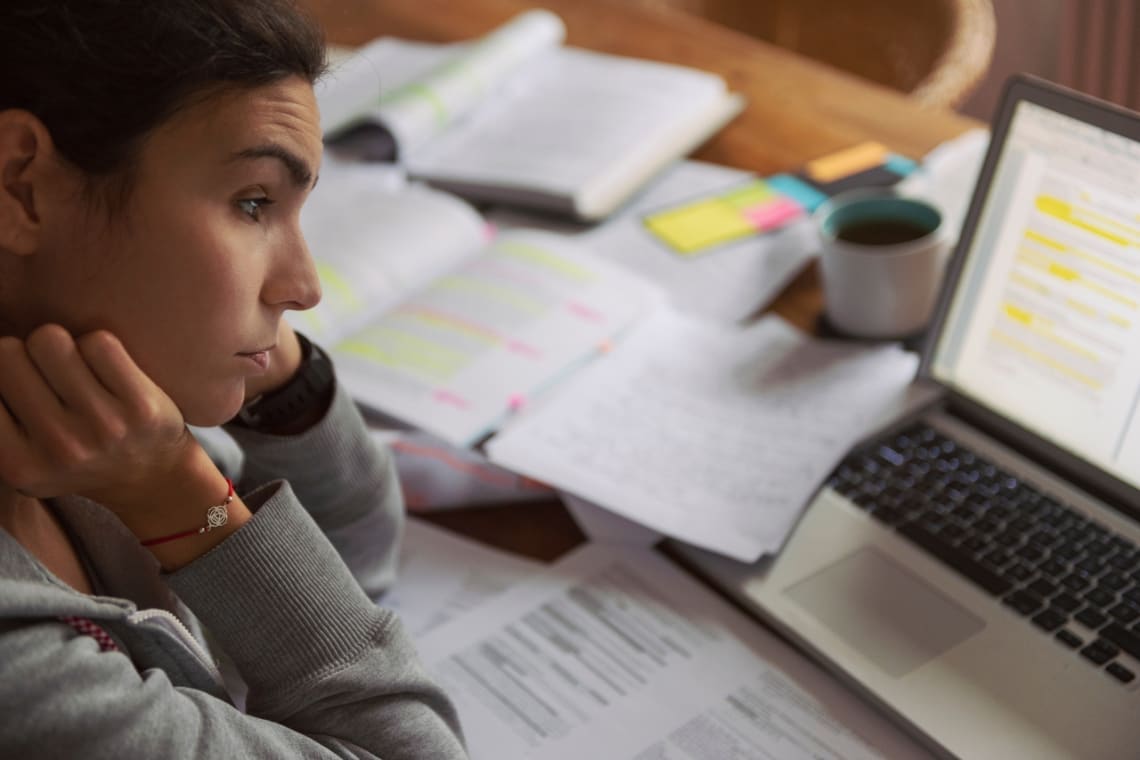 Young woman with burnout looking tired at a computer 