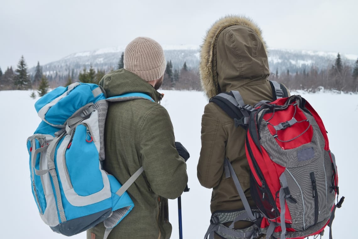 Backpacking checklist: two warmly clothed people on a snowy natural place