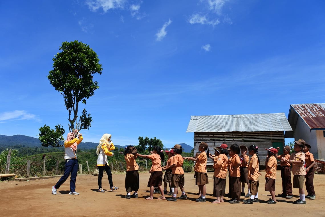 Two muslim teachers with kids in a rural school