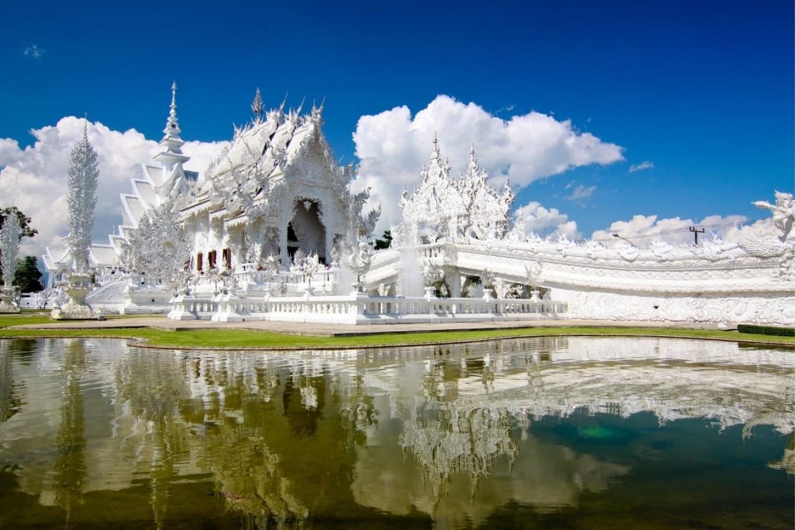 Templo Blanco de Chiang Rai reflejándose en el lago artificial