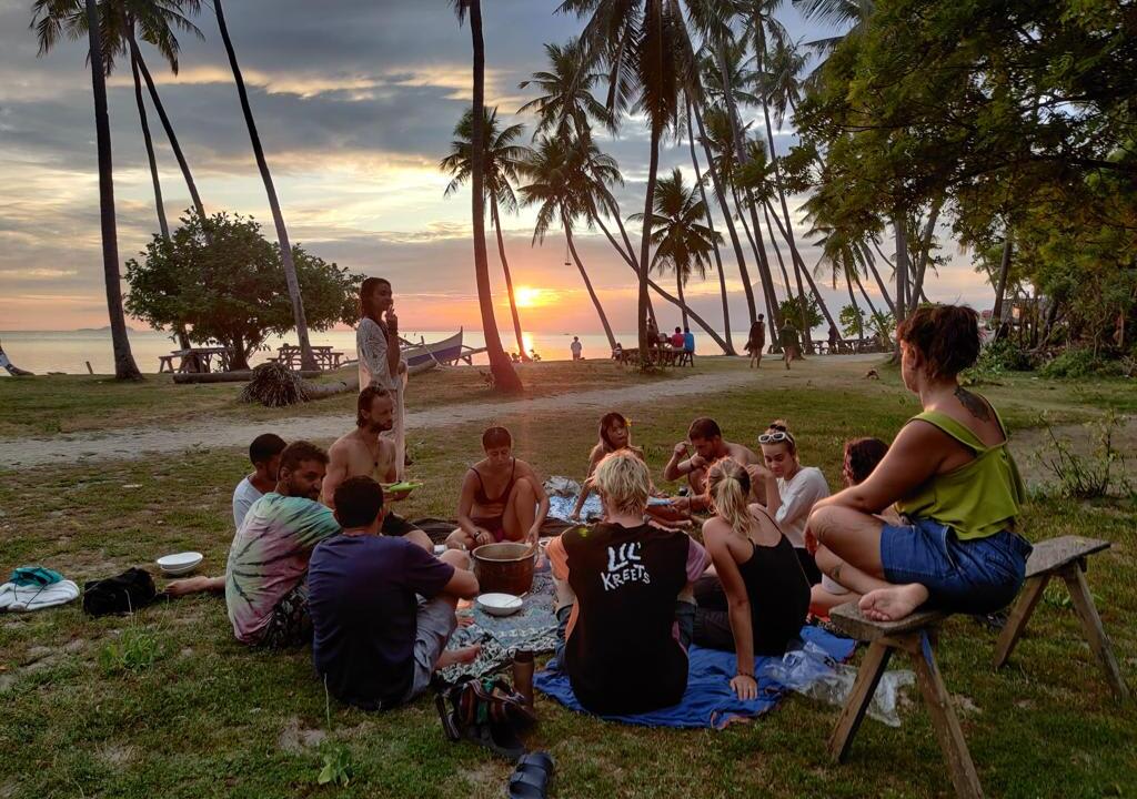 group of travelers and volunteers from a surf camp doing a picnic at the beach