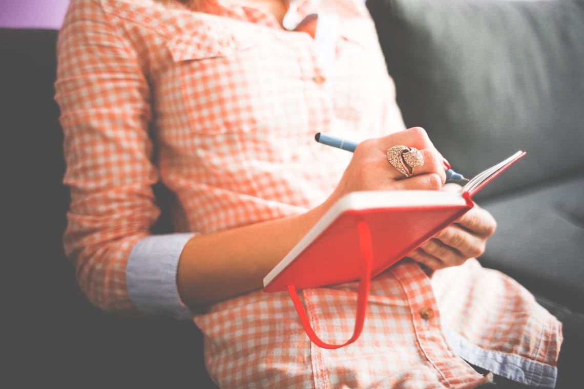 Chica escribiendo en una libreta