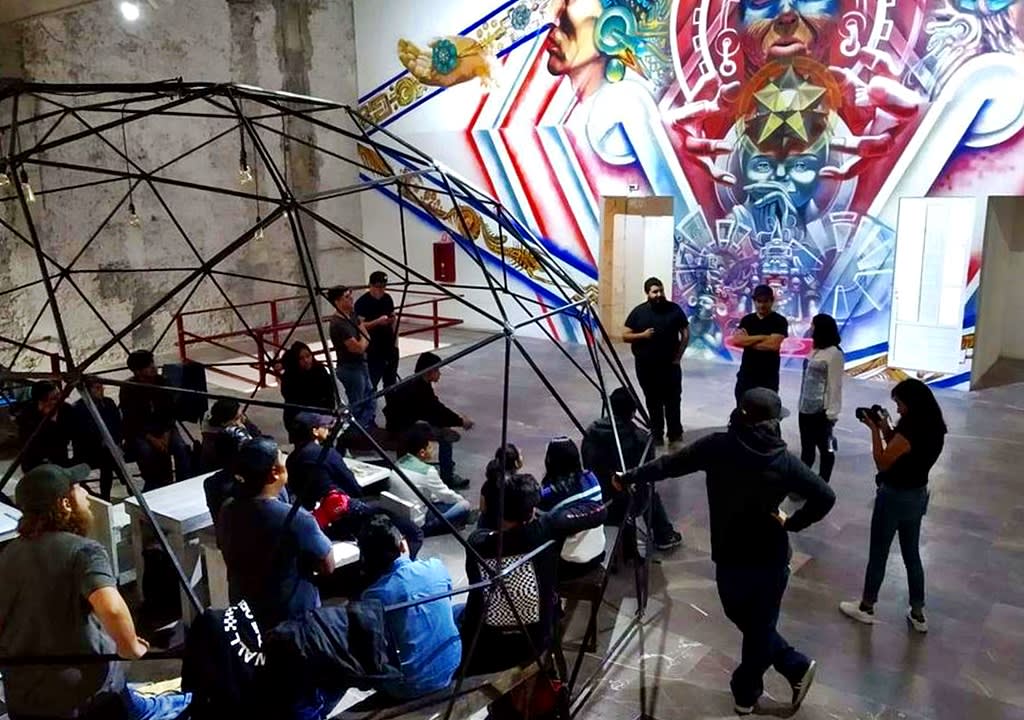 Gente dentro de un domo descubierto y mural en un centro cultural