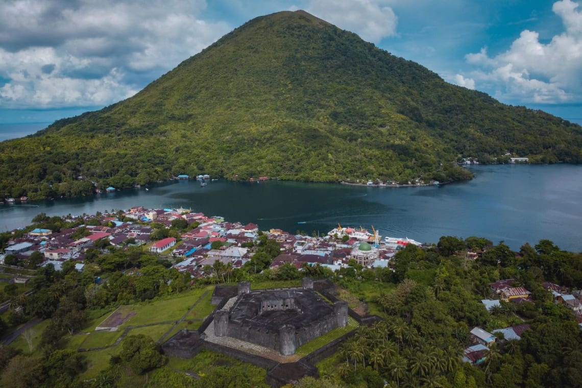 Destinos exóticos: vista desde mirador de pueblo de las Molucas junto al mar con fuerte colonial