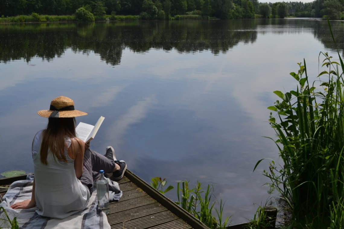 How to recover from burnout: girl reading next to a lake