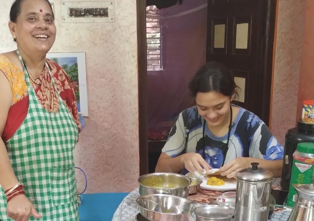 a young volunteer and her host cooking together in India