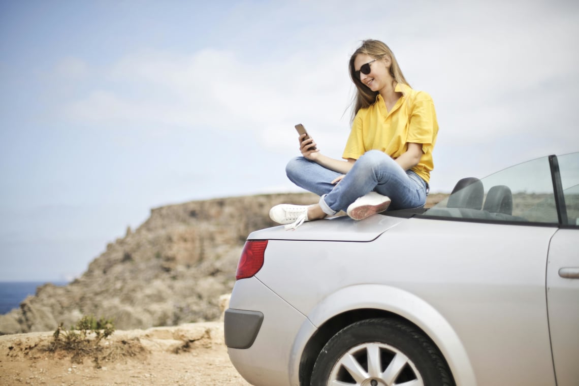 a woman using her phone during a roadtrip