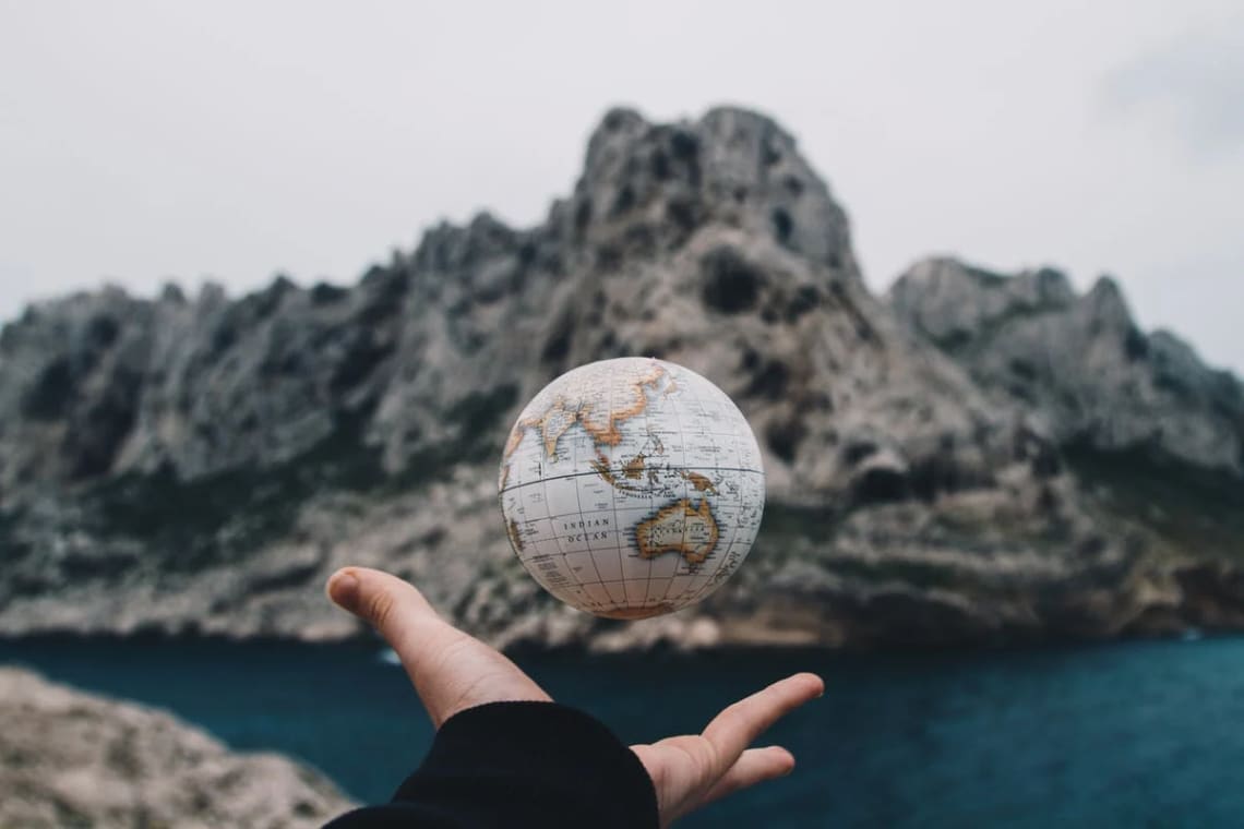 Hand playing with a small globe