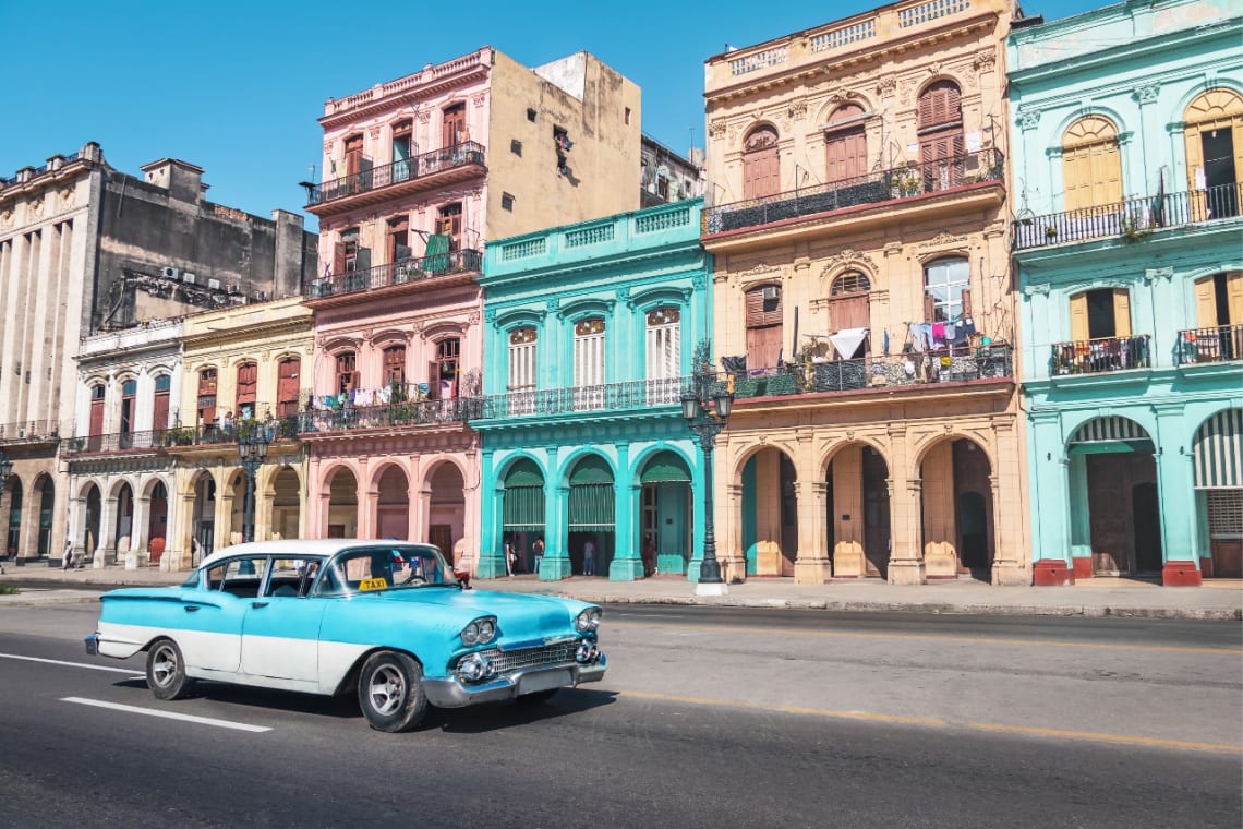 Mejor época para viajar a Cuba: auto clásico color celeste y blanco paseando por las calles de La Habana