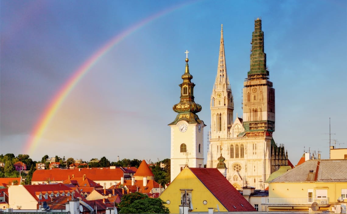 Catedral de Zagreb vista desde lejos con arcoíris detrás 