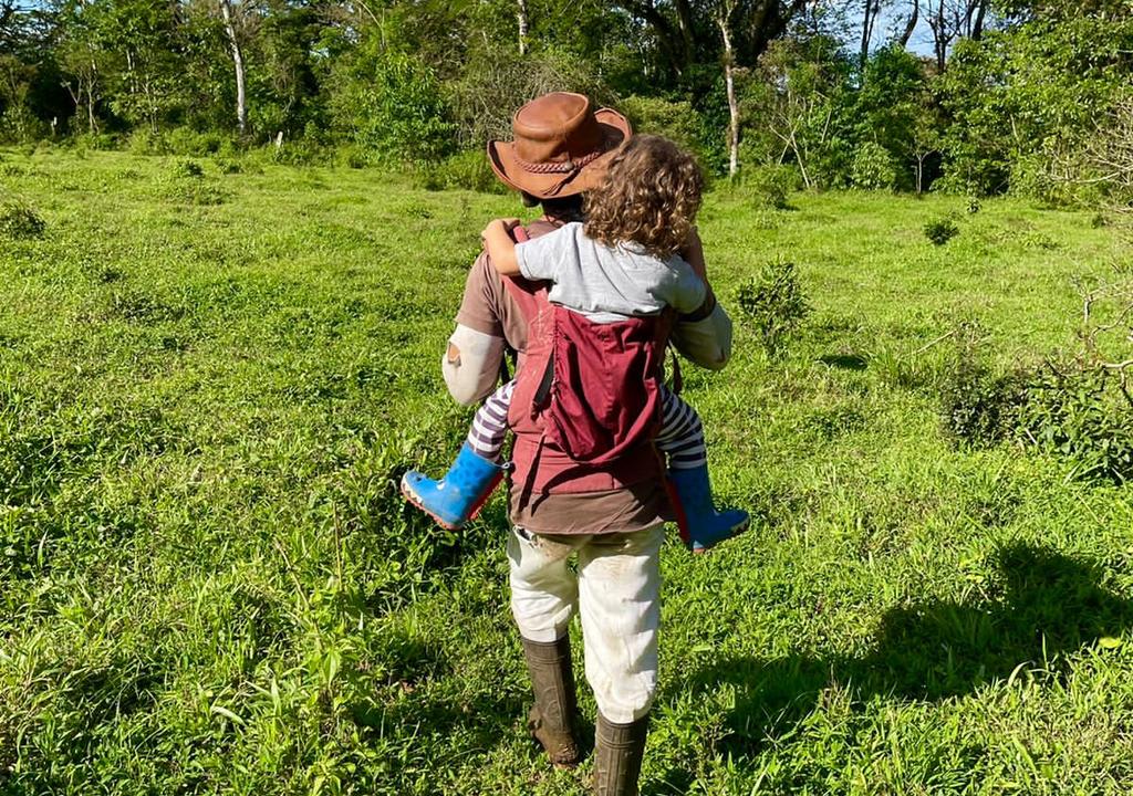 Adulto carrega criança nas costas em um retiro na Costa Rica