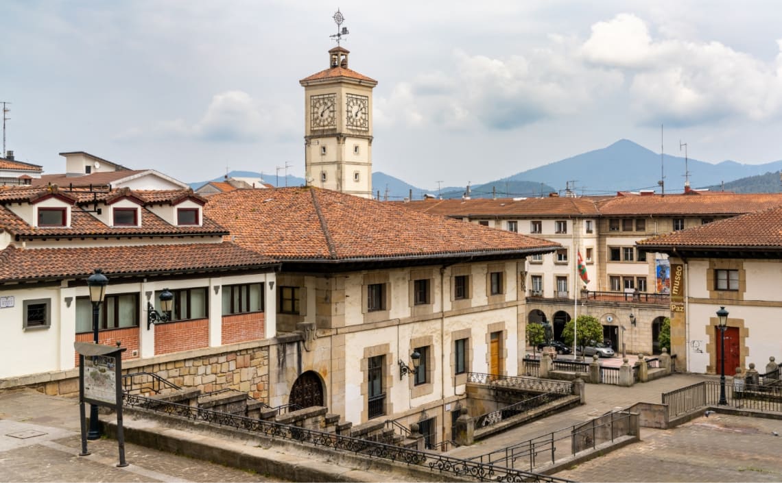 Edificios de tejas rojas y campanario en el casco histórico de Guernica