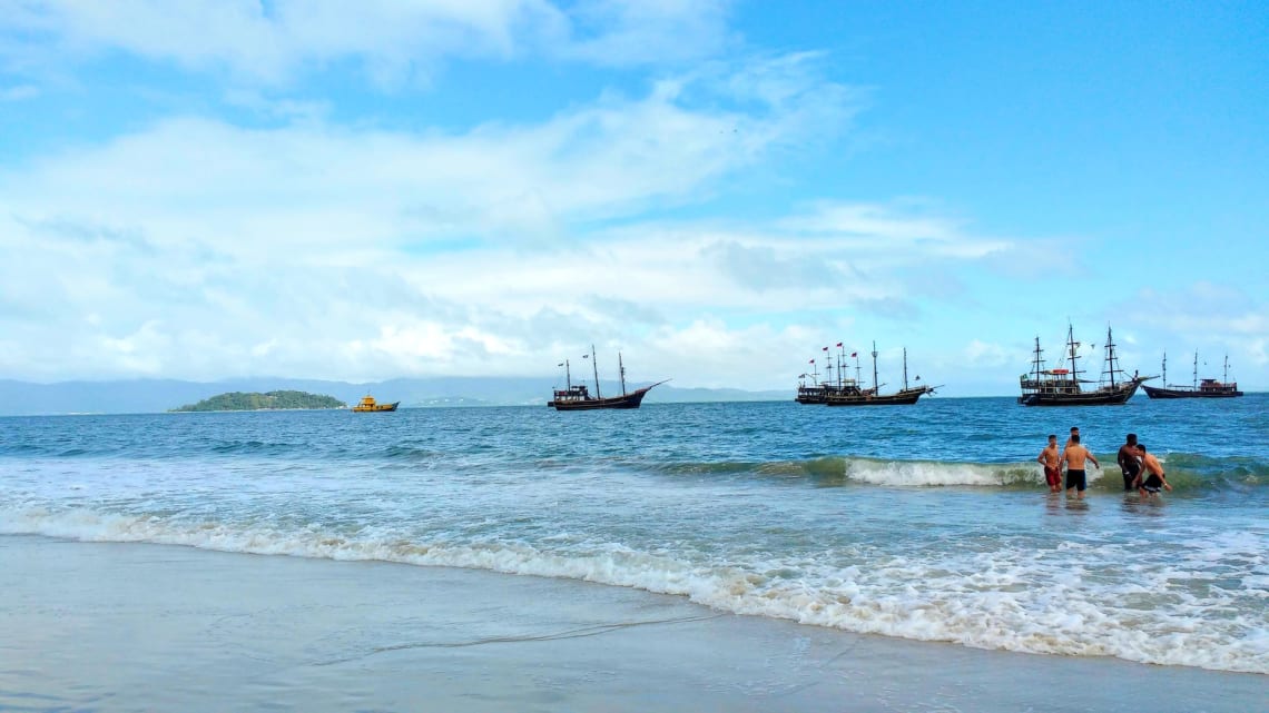 "Barcos piratas" y grupo de amigos tomando un baño en la Playa de Canasvieiras, Florianópolis